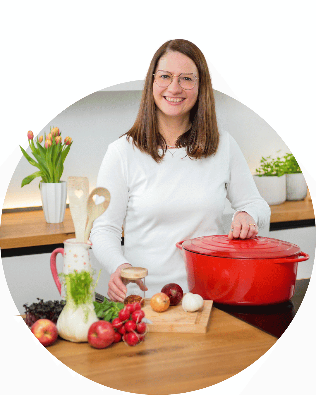 Hanna steht in der Küche zwischen Gemüse und Töpfe